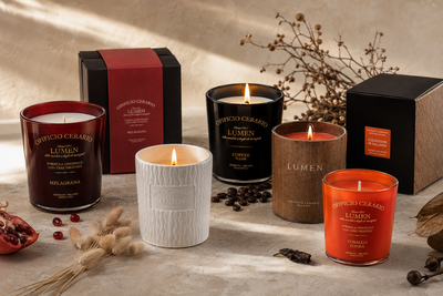 Candele profumate Opificio Cerario Lumen in diverse fragranze, tra cui Melagrana, Coffee Please e Tabacco Tonka, con confezioni regalo